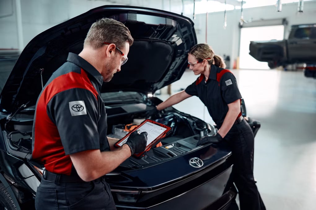 Two Toyota technicians installing parts into a car in Warrenton, OR